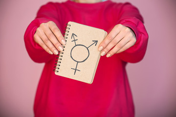 Woman showing symbol of transgender on color background, closeup