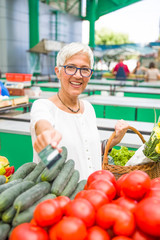 Fototapeta premium Senior woman holds credit card on market