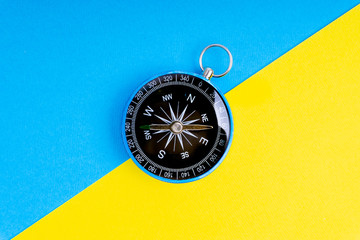 Compass on a blue and yellow background with selective focus