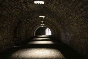 Tunnel of old castle with the light at the end.