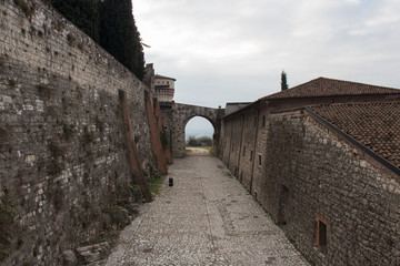 Part of a tower and a gate connecting to the wall of the Brescia Castle, Lombardy, Italy.
