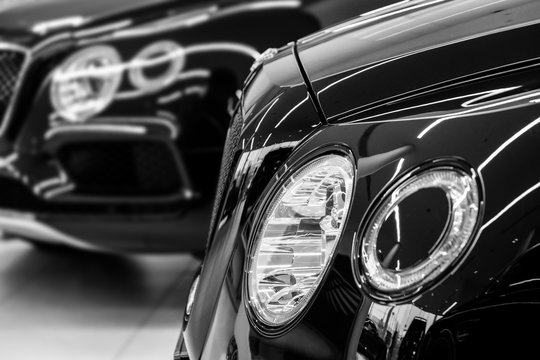 Headlights of luxury car at dealer showroom