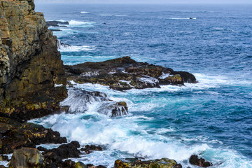 Sea cliffs in blue waters of the Pacific ocean