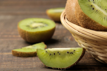 Delicious ripe many kiwi fruit and kiwi in a cut on a brown wooden table. close-up.