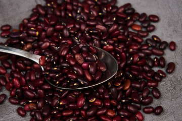 Beans red with a spoon on a dark background close-up