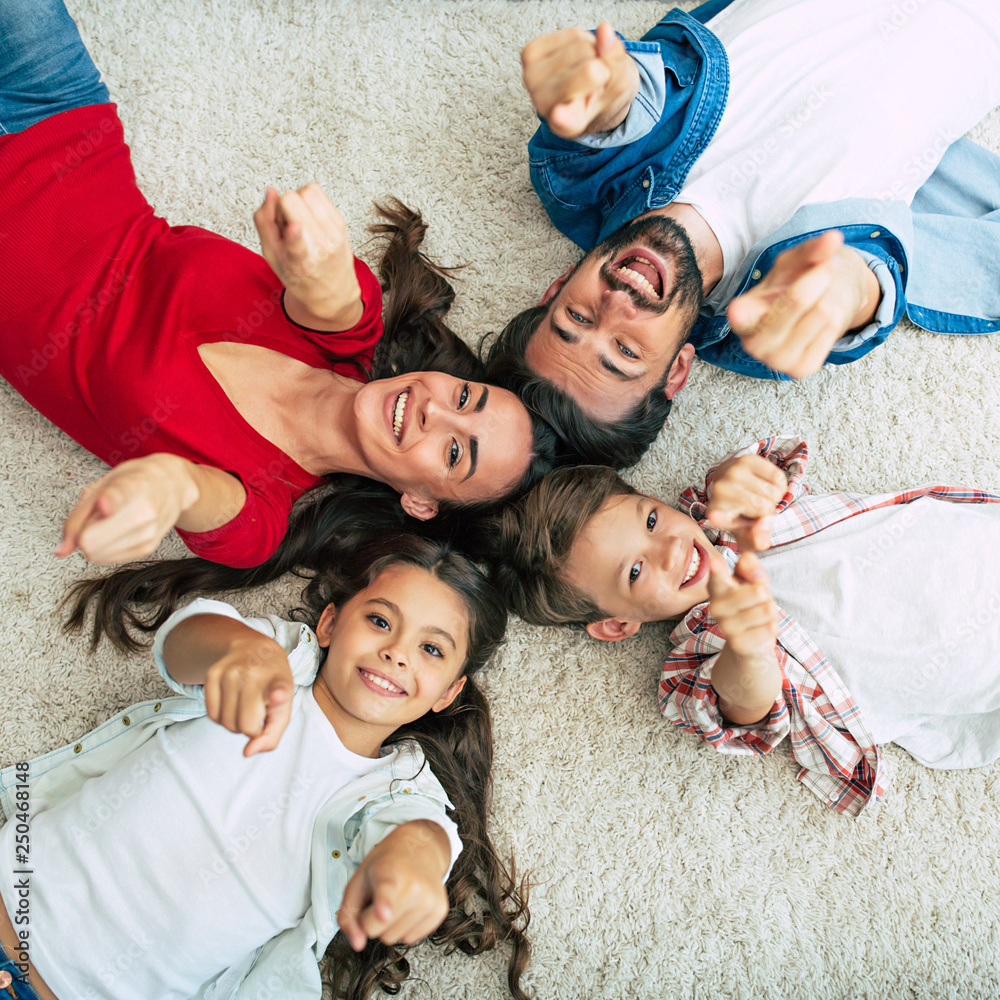 Wall mural Top view photo of young happy family lying on the floor, have a fun and smiling