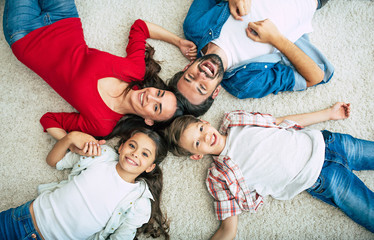Top view photo of young happy family lying on the floor, have a fun and smiling