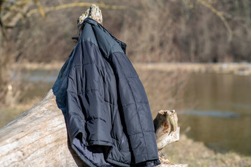 The owner of this coat dressed for the unusually warm weather in winter far too warmly. He took it off and used the old tree stump as a coat hanger. Unfortunately he forgot when he left.