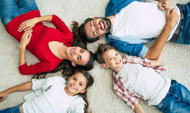 Top view photo of young happy family lying on the floor, have a fun and smiling