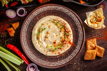 The concept of Arabic cuisine. Oriental hummus with grilled sesame and pistachios. Laid arabic...