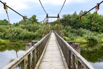 Fototapeta na wymiar Svencele, Klaipeda county, Lithuania - August 14, 2018: Wooden hanging bridge over King Wilhelm channel. Tourist destination in Klaipeda county in Lithuania.