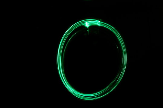 Long Exposure, Light Painting Photography.  Abstract Circle Outline Design, Vibrant Green Color Against A Black Background