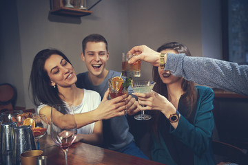 Photo of joyful friends in the bar or at pub communicating with each other
