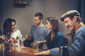 Photo of joyful friends in the bar or at pub communicating with each other