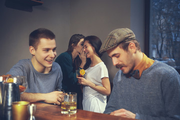 Photo of joyful friends in the bar or at pub communicating with each other