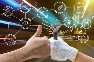 Mechanic hand checking and fixing a broken car in  garage.hand of mechanic with thumbs up and tool