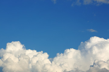 Naklejka na ściany i meble fluffy white cloud above clear blue sky background
