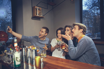 Photo of joyful friends in the bar or at pub communicating with each other