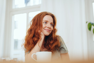 Beautiful red-haired girl with cup of tea