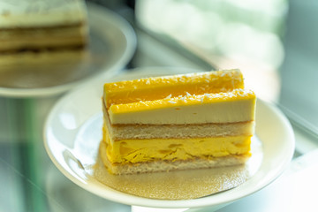 The yellow cake is divided into pieces placed in the dish.