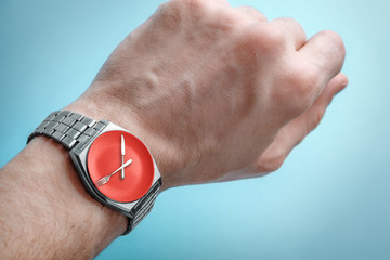Fototapeta premium Wrist watch on man's hand. Plate, knife and fork on clock face. Concept of intermittent fasting, lunchtime
