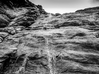 Beautiful waterfall over mossy stones in the Cove of Tintagel in Cornwall
