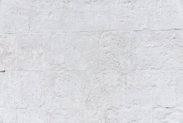 Grunge retro white background from old wall of stones. Texture of old painted white stone wall.