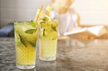 Glasses of iced lemonade on table indoors