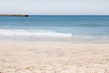 Picturesque view of beautiful beach with stone breakwater on sunny day