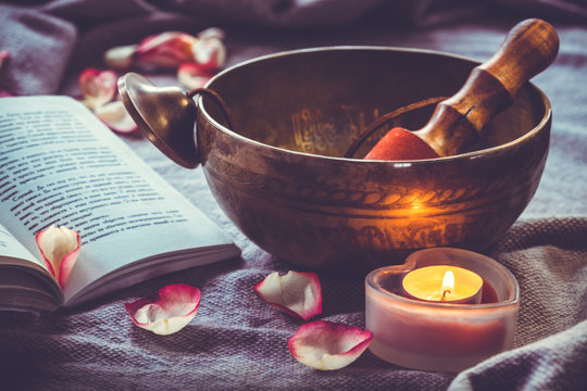 Tibetan singing bowl with book candel and rose petal