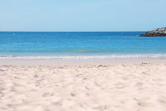 Picturesque view of beautiful beach with stone breakwater on sunny day