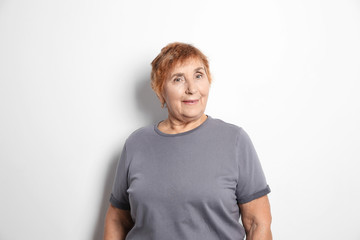 Obraz premium Portrait of elderly woman on light background