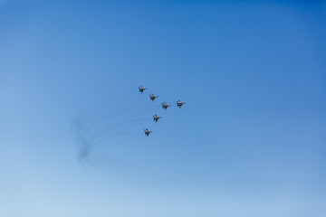 a triangular formation of a group of six russian military fighter jet planes flying high in blue sky