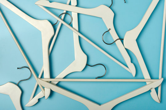 F lot of handers. Wooden clothes white hanger set jn light blue background.
