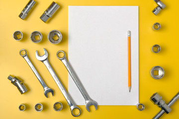 Spanners of different sizes for car enthusiasts. Top view of different wrenches on yellow background with copy space.