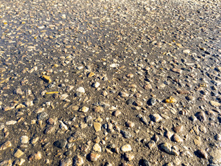 Pebbles on the road. Stones in the asphalt road.