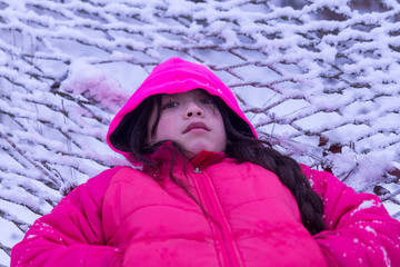 Young Asian girl laying in the snow