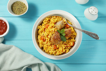 Delicious rice pilaf served on wooden table, flat lay