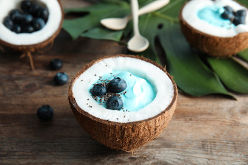 Coconut with spirulina smoothie on wooden table