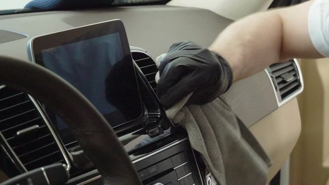 Car wash and detailing. A man cleaning the car interior of luxury modern automobile. 4K