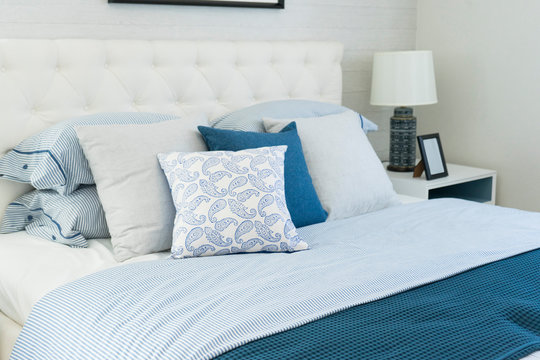 beach blue pillow on bed with side table lamp in bedroom