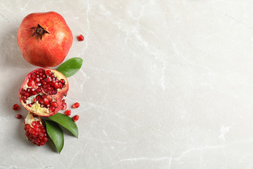 Flat lay composition with ripe pomegranates and space for text on light background