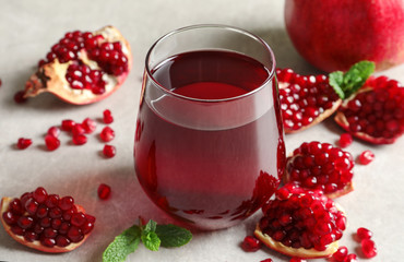 Composition with glass of fresh pomegranate juice on table