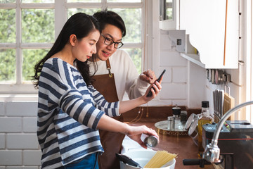 Asian couple family cooking food together in kitchen, happy family lifestyle