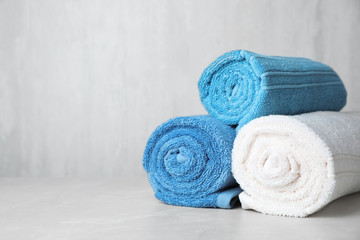 Rolled bath towels on table. Space for text