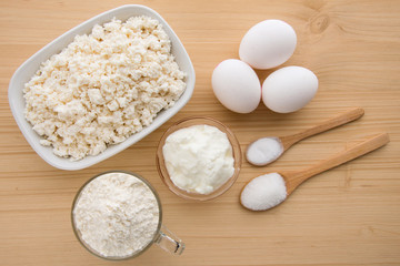 Ingredients on the wooden table, cooking a cheesecake.