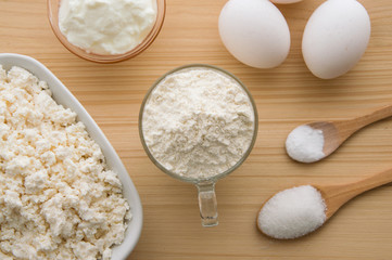 Ingredients on the wooden table, cooking a cheesecake.