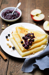 Crepes with Black Currant Jam on Dark Wooden Background
