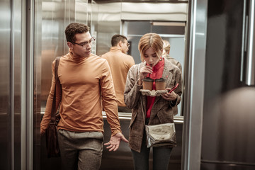 Slim blonde-haired girlfriend drinking coffee in the elevator © zinkevych