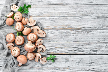 Mushrooms on a white wooden background. Champignons Top view. Free copy space.